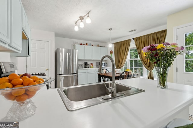 570 White Stag Ct, Suwanee, GA 30024 - kitchen featuring freestanding refrigerator, light countertops, hanging light fixtures, and white cabinets