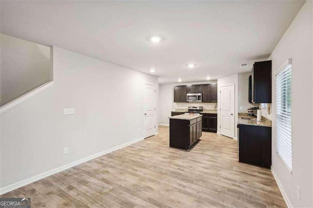 382 Daffodil Dr, Temple, GA 30179 - kitchen with stainless steel microwave, a center island, recessed lighting, light countertops, and light wood-type flooring