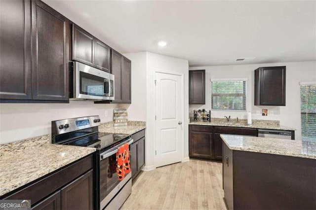 382 Daffodil Dr, Temple, GA 30179 - kitchen with appliances with stainless steel finishes, light wood-style floors, light stone countertops, dark brown cabinetry, and recessed lighting