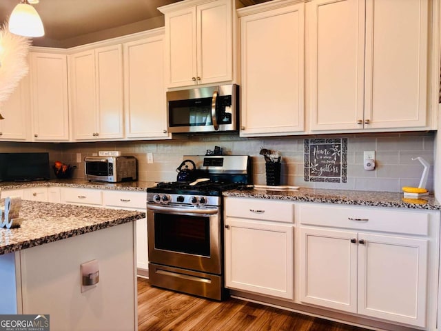 38 Lavender Ct, Dallas, GA 30132 - kitchen with stainless steel appliances, light stone countertops, white cabinets, and tasteful backsplash