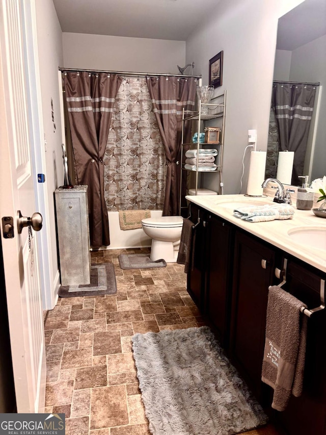 38 Lavender Ct, Dallas, GA 30132 - bathroom featuring double vanity, toilet, shower / bathtub combination with curtain, and stone finish flooring
