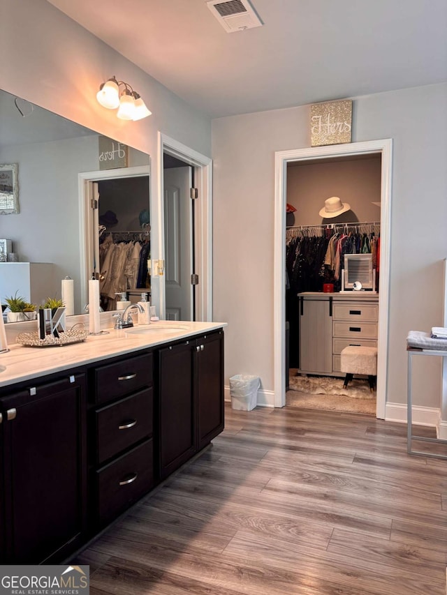 38 Lavender Ct, Dallas, GA 30132 - full bathroom with a walk in closet, vanity, wood finished floors, and baseboards