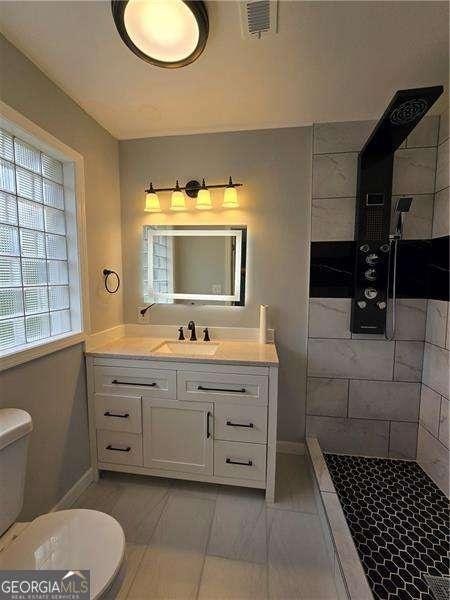 766 Longleaf Dr, Forest Park, GA 30297 - full bathroom with toilet, baseboards, and a tile shower