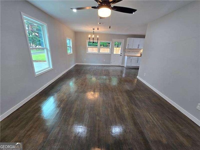 766 Longleaf Dr, Forest Park, GA 30297 - unfurnished living room featuring dark wood-style flooring, a chandelier, ceiling fan, and baseboards