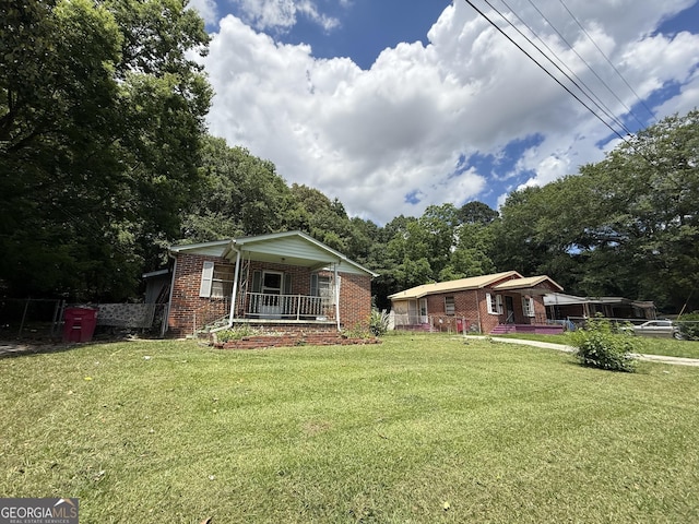 895 Ell Ct, Macon, GA 31206 - view of front of property with a porch, brick siding, a front yard, and view of scattered trees