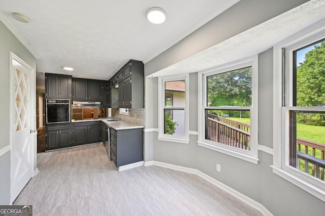 2676 Abington Dr, Snellville, GA 30078 - kitchen with black oven, a sink, light countertops, baseboards, and tasteful backsplash