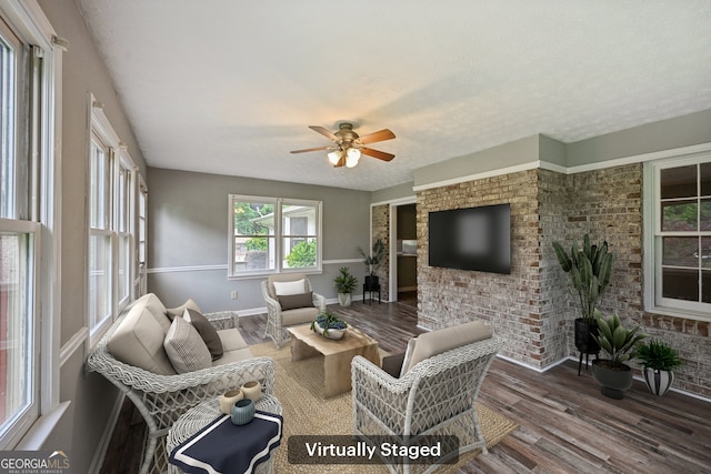 2676 Abington Dr, Snellville, GA 30078 - living room featuring wood finished floors, a ceiling fan, baseboards, and brick wall