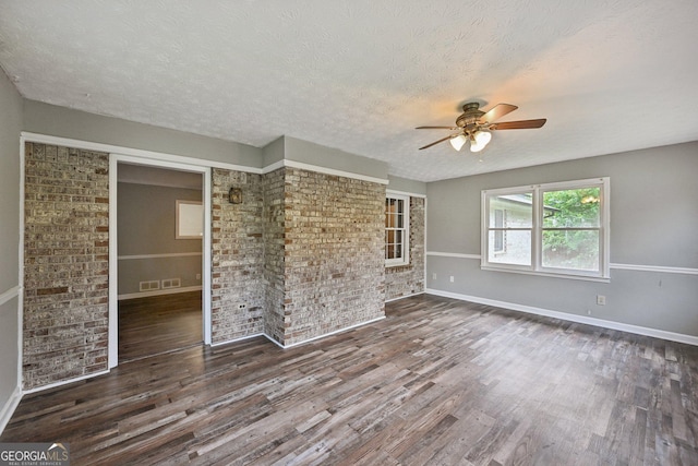 2676 Abington Dr, Snellville, GA 30078 - spare room featuring a ceiling fan, wood finished floors, a textured ceiling, baseboards, and brick wall