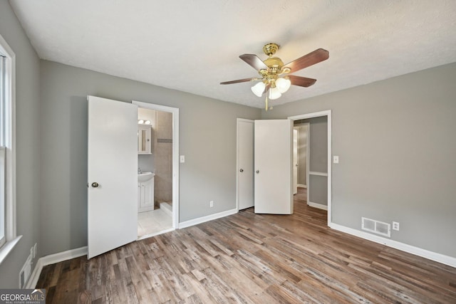 2676 Abington Dr, Snellville, GA 30078 - unfurnished bedroom with wood finished floors, baseboards, and connected bathroom