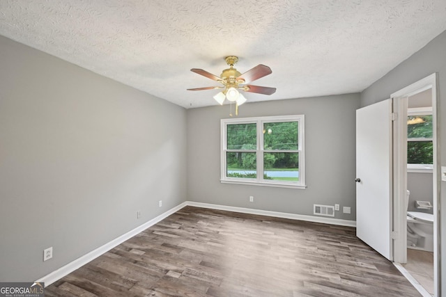 2676 Abington Dr, Snellville, GA 30078 - unfurnished bedroom featuring wood finished floors, a textured ceiling, baseboards, and ceiling fan