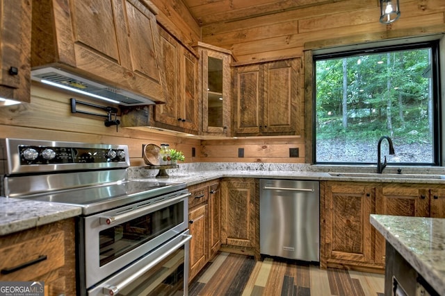 968 Hidden Valley Dr, Morganton, GA 30560 - kitchen with appliances with stainless steel finishes, a sink, brown cabinets, light stone counters, and wooden walls