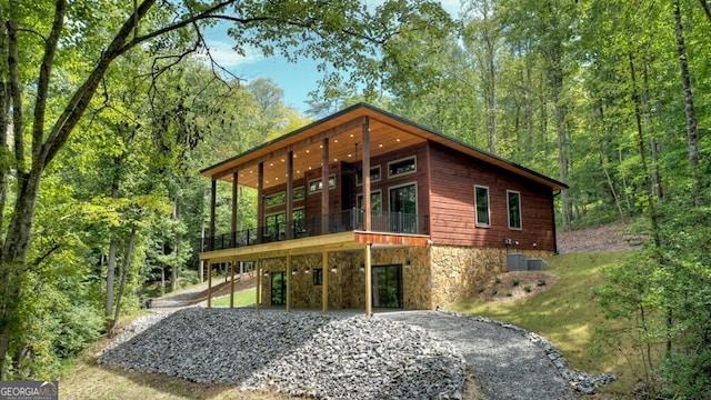 968 Hidden Valley Dr, Morganton, GA 30560 - view of front of house featuring asphalt driveway, a carport, stone siding, a wooden deck, and a forest view