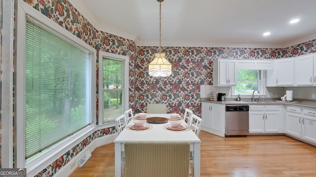 224 Rolling Oaks Dr, Rome, GA 30165 - kitchen with dishwasher, wallpapered walls, crown molding, light wood finished floors, and white cabinetry