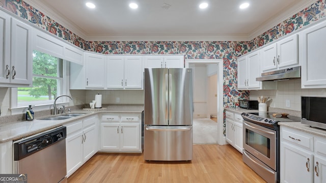 224 Rolling Oaks Dr, Rome, GA 30165 - kitchen with stainless steel appliances, under cabinet range hood, a sink, light wood-style flooring, and crown molding