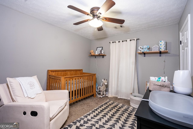 710 Newton Rd, Lagrange, GA 30240 - carpeted bedroom featuring a crib, a textured ceiling, and a ceiling fan