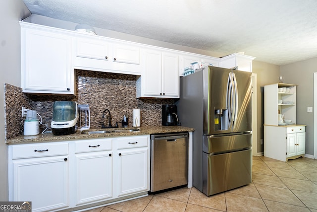 710 Newton Rd, Lagrange, GA 30240 - kitchen featuring appliances with stainless steel finishes, white cabinets, tasteful backsplash, light tile patterned floors, and a textured ceiling