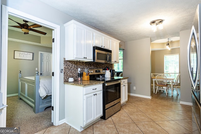 710 Newton Rd, Lagrange, GA 30240 - kitchen with stainless steel appliances, decorative backsplash, white cabinetry, ceiling fan, and light tile patterned flooring