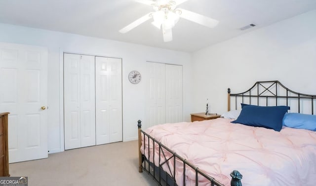393 Arrowhead Trl, Eatonton, GA 31024 - bedroom featuring two closets, light colored carpet, and a ceiling fan