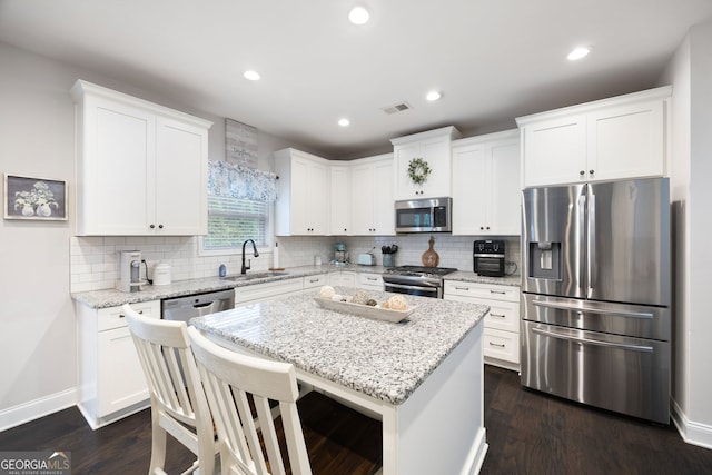372 Cobblestone Trl, Dallas, GA 30157 - kitchen with stainless steel appliances, a sink, decorative backsplash, a kitchen island, and white cabinets