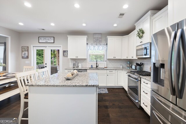 372 Cobblestone Trl, Dallas, GA 30157 - kitchen featuring appliances with stainless steel finishes, a sink, a breakfast bar, decorative backsplash, and recessed lighting