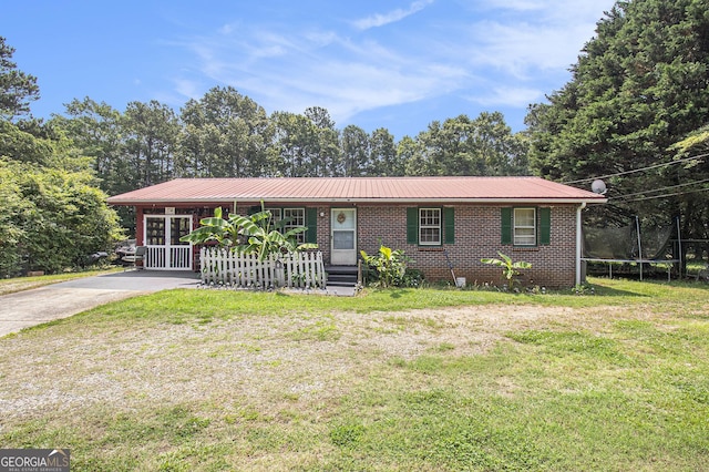 564 Peters St, Statham, GA 30666 - ranch-style home with a trampoline, brick siding, a front lawn, and metal roof