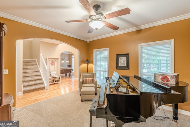 5767 Wembley Dr, Douglasville, GA 30135 - living area featuring arched walkways, ornamental molding, a ceiling fan, plenty of natural light, and stairway