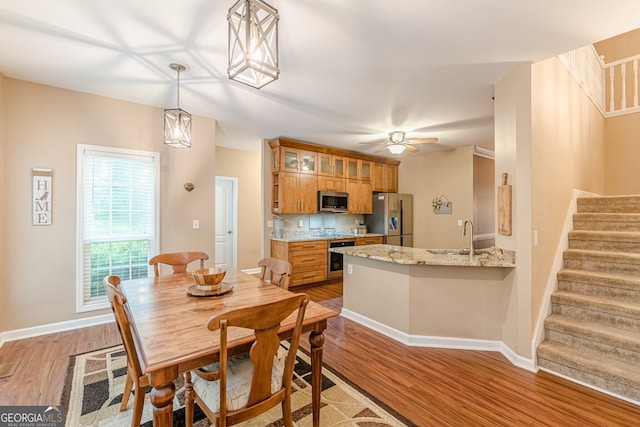 5767 Wembley Dr, Douglasville, GA 30135 - dining area featuring stairs, light wood-style flooring, ceiling fan, and beverage cooler