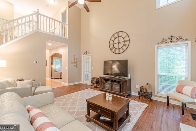 5767 Wembley Dr, Douglasville, GA 30135 - living room featuring a towering ceiling, ceiling fan, wood finished floors, and arched walkways