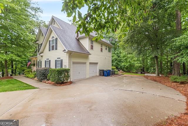 5767 Wembley Dr, Douglasville, GA 30135 - view of side of home with a shingled roof, driveway, and an attached garage