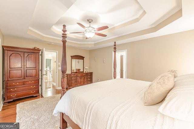 5767 Wembley Dr, Douglasville, GA 30135 - bedroom featuring a raised ceiling, ornamental molding, light wood finished floors, connected bathroom, and ceiling fan