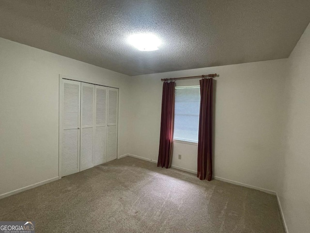 404 S Baker St, Glennville, GA 30427 - unfurnished bedroom with carpet, a textured ceiling, a closet, and baseboards