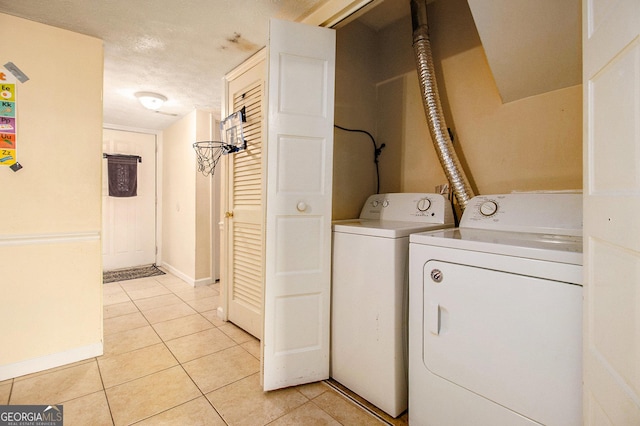 6433 Stone Ter, Morrow, GA 30260 - washroom with washing machine and dryer, light tile patterned floors, baseboards, and a textured ceiling