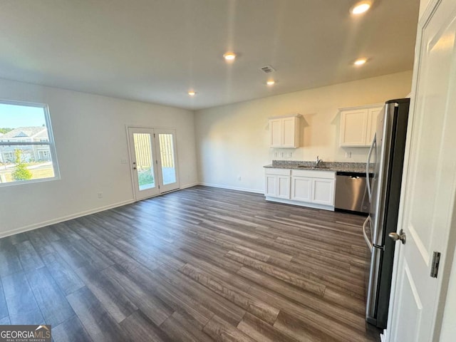 268 Rydal Way, Winder, GA 30680 - unfurnished living room featuring healthy amount of natural light, dark wood-style floors, recessed lighting, and baseboards