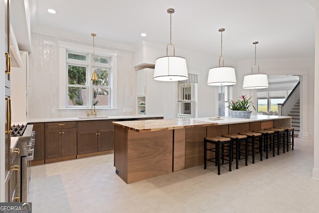 50 Frederica Oaks Ln, Saint Simons, GA 31522 - kitchen with a sink, a breakfast bar, stainless steel stove, healthy amount of natural light, and recessed lighting