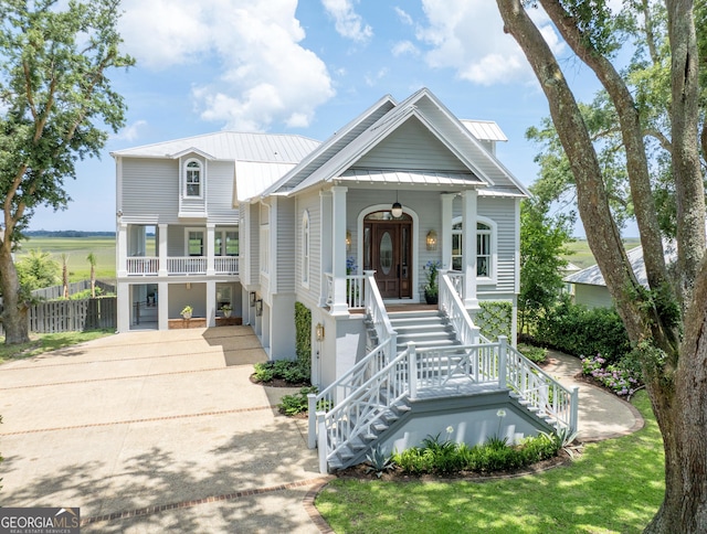 50 Frederica Oaks Ln, Saint Simons, GA 31522 - view of front of home with covered porch, stairway, driveway, metal roof, and a standing seam roof