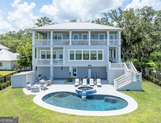 50 Frederica Oaks Ln, Saint Simons, GA 31522 - rear view of house featuring a balcony, a patio area, and a pool with connected hot tub