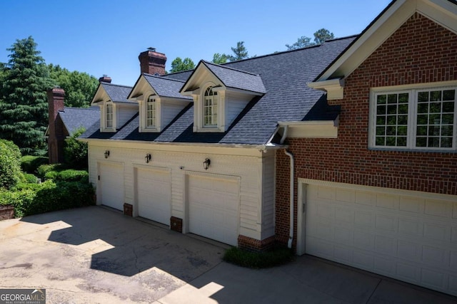 4790 Shallowford Rd, Roswell, GA 30075 - view of home's exterior with brick siding, concrete driveway, a chimney, a shingled roof, and a garage