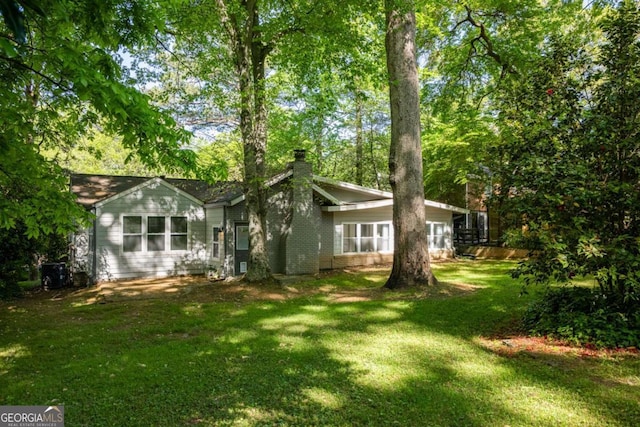 1002 Forrest Blvd, Decatur, GA 30030 - back of house with a chimney, a yard, and central air condition unit