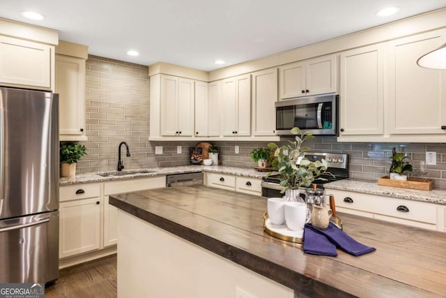 1002 Forrest Blvd, Decatur, GA 30030 - kitchen featuring stainless steel appliances, a sink, butcher block counters, decorative backsplash, and dark wood-style flooring