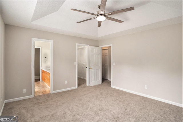 75 Plantation Ln, Locust Grove, GA 30248 - unfurnished bedroom with light colored carpet, a walk in closet, ensuite bathroom, a closet, and a ceiling fan