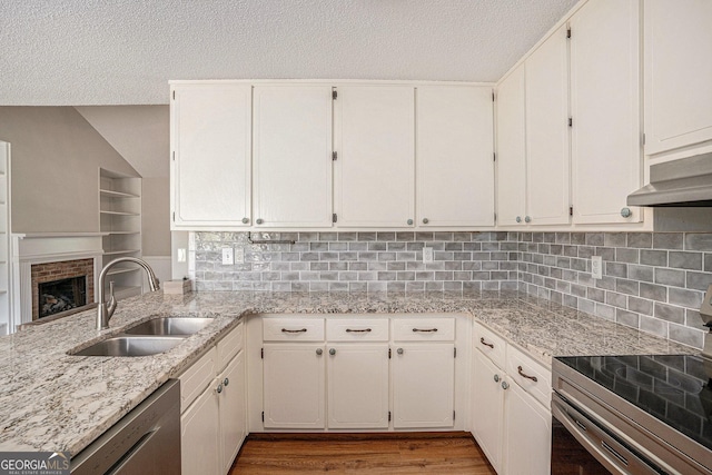 75 Plantation Ln, Locust Grove, GA 30248 - kitchen with appliances with stainless steel finishes, a textured ceiling, ventilation hood, light stone counters, and wood finished floors
