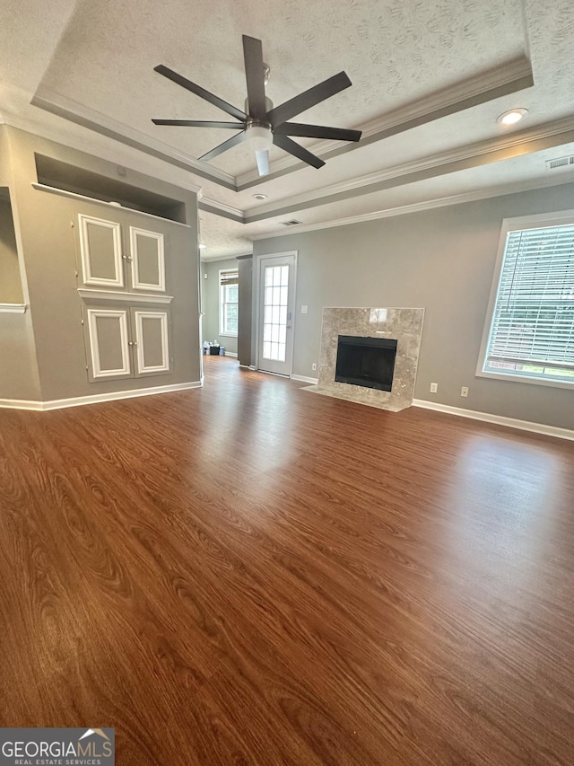 80 Fields Creek Way, Covington, GA 30016 - unfurnished living room with a tray ceiling, wood finished floors, a textured ceiling, ceiling fan, and crown molding