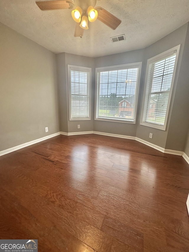 80 Fields Creek Way, Covington, GA 30016 - spare room with a textured ceiling, dark wood-style floors, a ceiling fan, and plenty of natural light