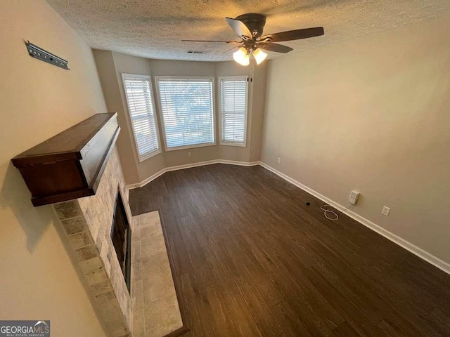 3251 Avensong Village Cir, Milton, GA 30004 - unfurnished room with a textured ceiling, ceiling fan, dark wood-style floors, baseboards, and a fireplace