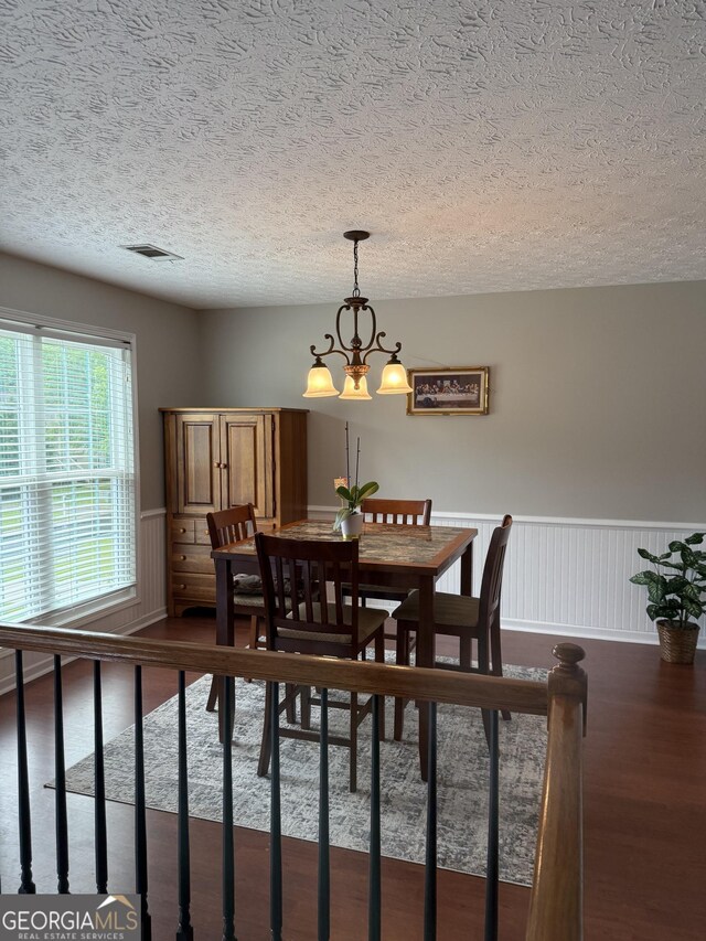 60 Buck Trl, Newnan, GA 30265 - dining room with a textured ceiling, dark wood-type flooring, a chandelier, and a wainscoted wall