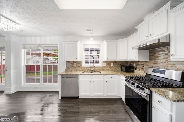 773 Minor Oaks Run NW, Lilburn, GA 30047 - kitchen featuring stainless steel appliances, under cabinet range hood, dark wood finished floors, a textured ceiling, and light stone counters