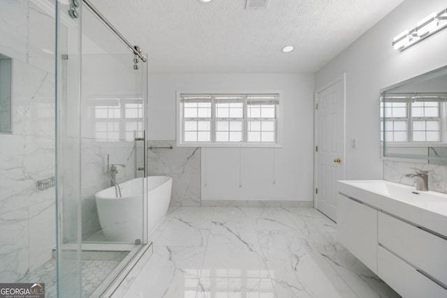 773 Minor Oaks Run NW, Lilburn, GA 30047 - bathroom featuring a textured ceiling, vanity, a freestanding tub, marble tiled flooring, and a marble finish shower