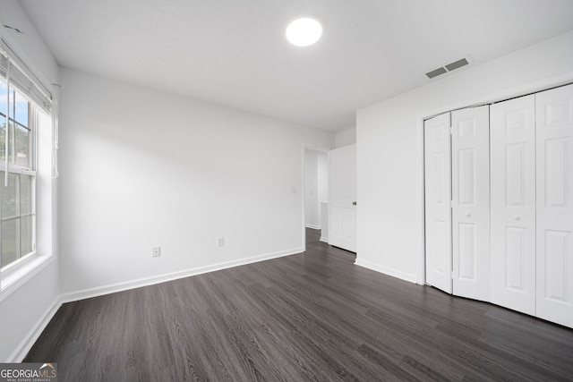 773 Minor Oaks Run NW, Lilburn, GA 30047 - unfurnished bedroom with dark wood-style floors and a closet