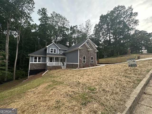 1119 Plantation Dr SE, Conyers, GA 30094 - view of front of house with covered porch, a front lawn, and brick siding