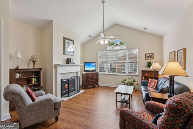 2565 Grapevine Cir Unit 103, Cumming, GA 30041 - living area featuring wood finished floors, a tiled fireplace, ceiling fan, and vaulted ceiling